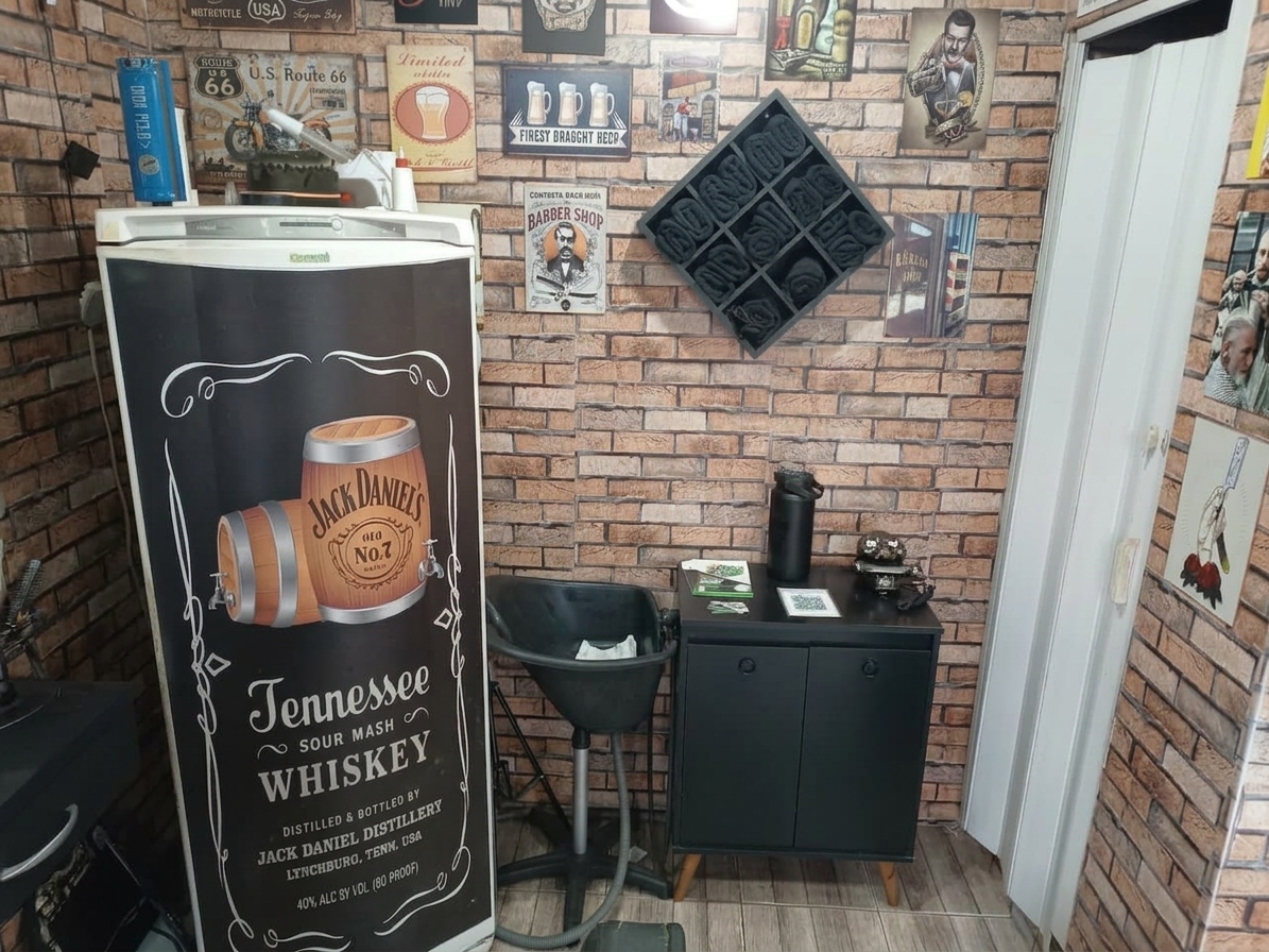 Canto da 1984 Barbershop com geladeira temática do Jack Daniel's, produtos e decoração vintage nas paredes de tijolo